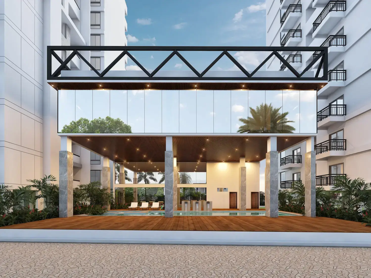 The clubhouse between the towers: a glass gallery under a steel truss, open to the pool deck.