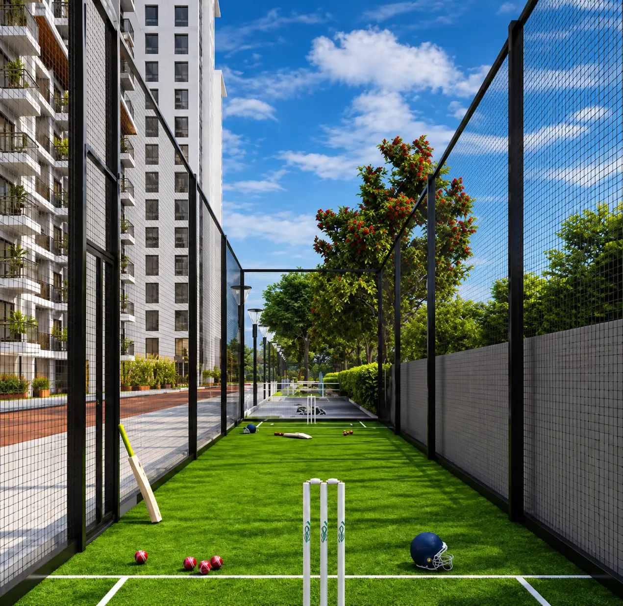 A netted cricket practice lane on green turf between the towers, stumps, bats and a helmet at the crease.