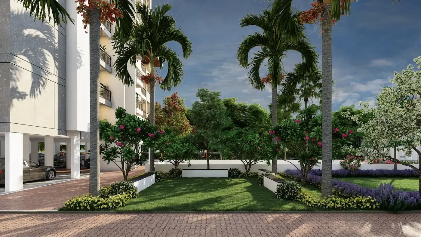 A lawn between the towers, ringed by palms, flowering shrubs and a paved walk.